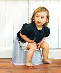 A little girl sitting on a potty chair.