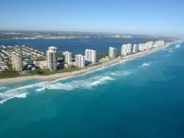 A aerial view of a shore line with hotels and roads.