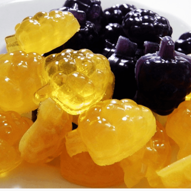 A pile of fruit shaped gummies on a table.