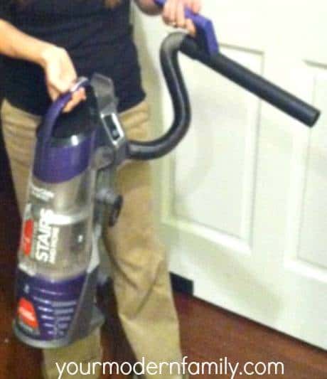 A person holding a hand held vacuum.