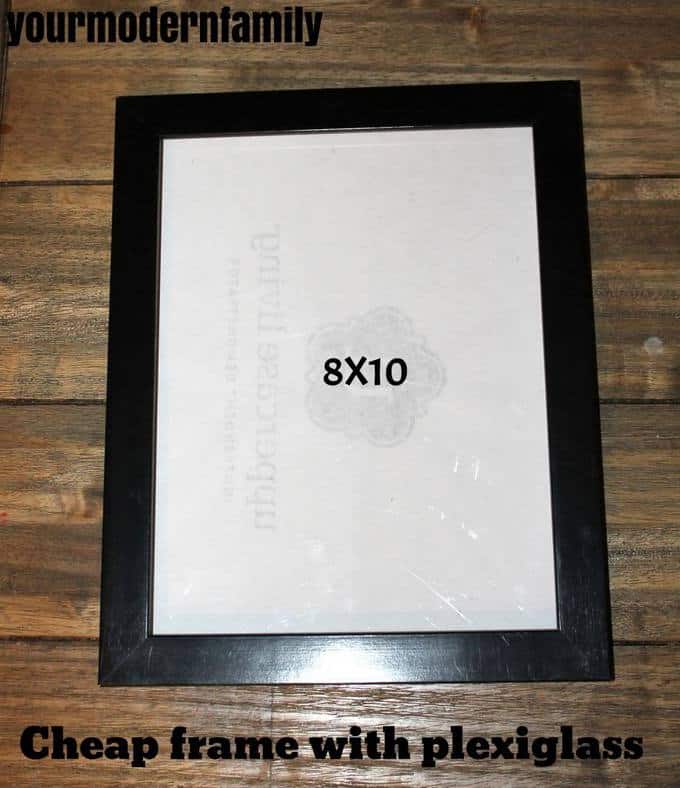 A black picture frame sitting on a table.