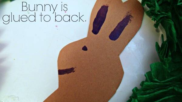 A brown paper bunny in the center of the wreath with text above it.