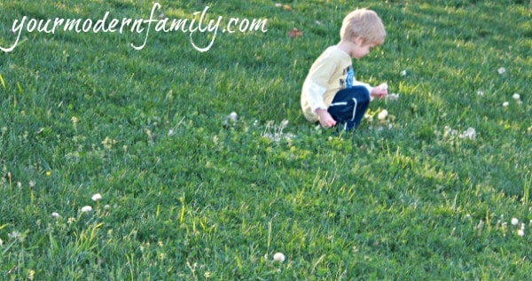 A young boy playing in a grassy field.