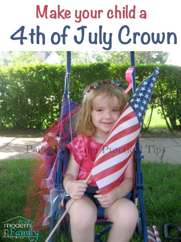 A little girl sitting in a stroller holding an American flag and wearing a Fourth of July crown.