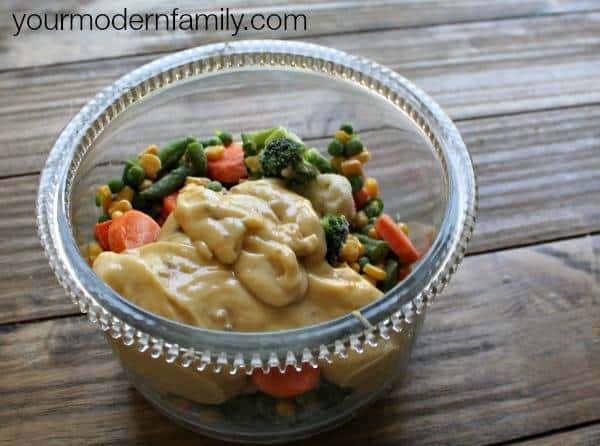 A bowl of mixed vegetables and cream of chicken soup in a plastic container.