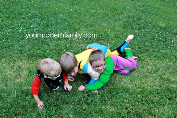 Three boys playing in the grass.