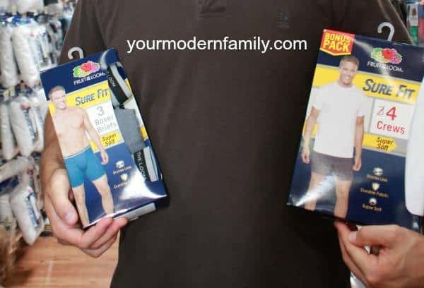 A man holding two packages of men\'s underwear.