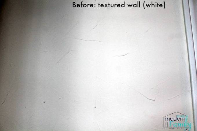 A white textured wall with text above it.
