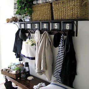 An entry way with numbered hooks for coats and a shelve for baskets.