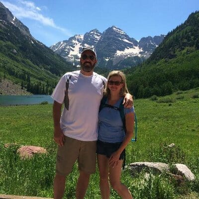 A couple standing in front of a mountain.