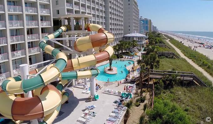 A water slide and pool at a hotel.