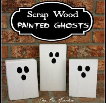 Wood scraps painted white to look like ghosts with text above them.