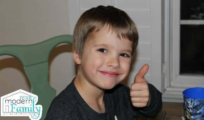 A little boy giving the thumbs up sign. 