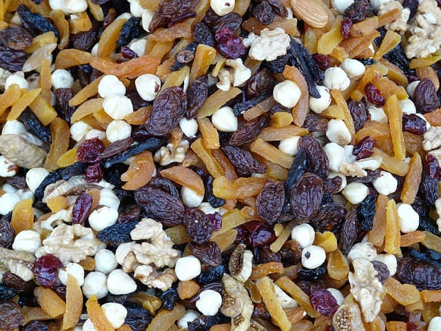 Healthy snack of raisins, yogurt bites and cut fruit.