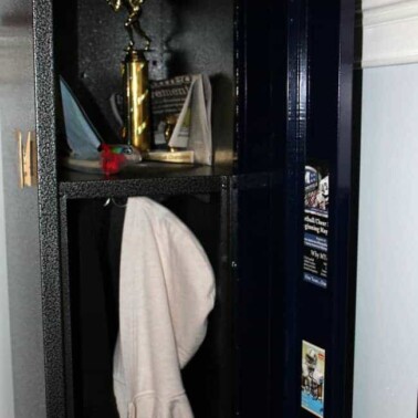 A close up of a sports locker holding a trophy and a sweatshirt.