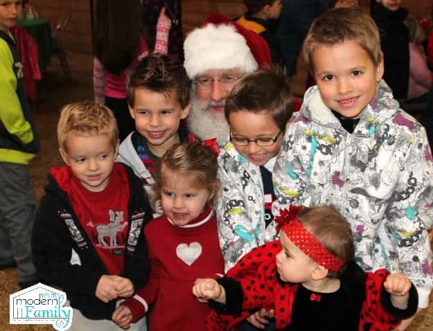 A group of young children sitting with Santa Clause.