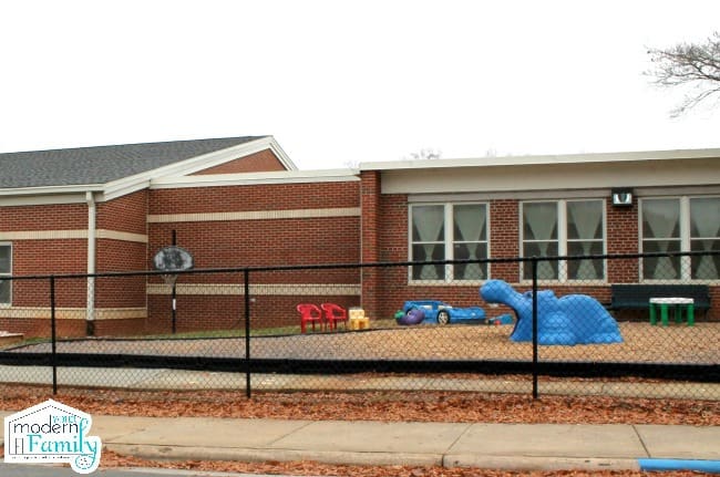 Picture of the outside of a school building with a playground.