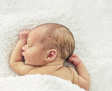 A baby lying on a bed.