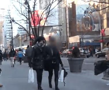 A group of people walking down a city street.