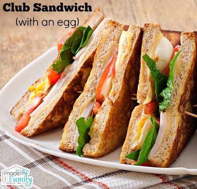 A club sandwich cut in half on a plate.