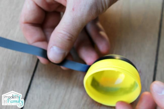 putting electrical tape on a yellow plastic easter egg