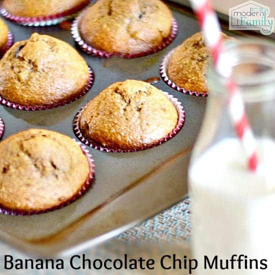 A close up of Banana Chocolate Chip muffins still in a muffin tin with a bottle of white milk beside them.