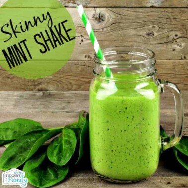 A green drink in a glass jar with a green and white straw and mint leaves beside it and text above it.