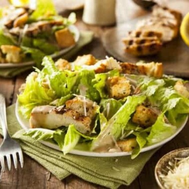 A plate of Caesar Salad on a table.