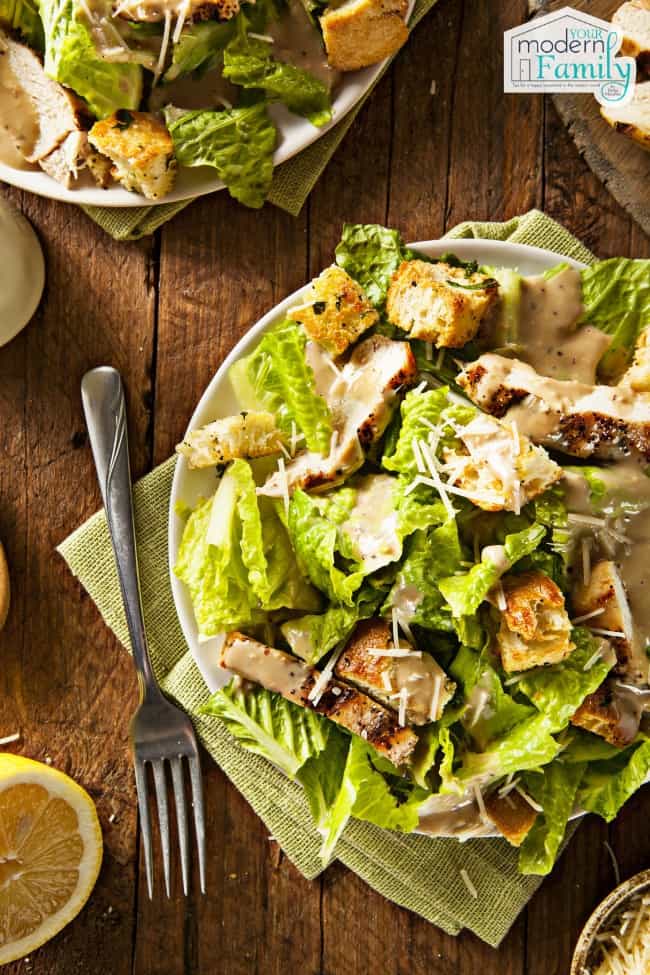 A plate of Caesar salad on a wooden table.