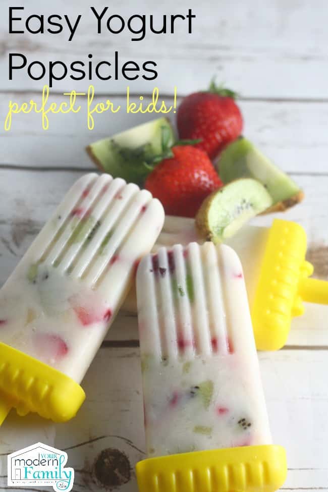 Fruit and yogurt popcicles on a wooden table.