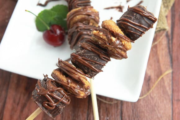 Cookies and candies on skewers resting on a plate.