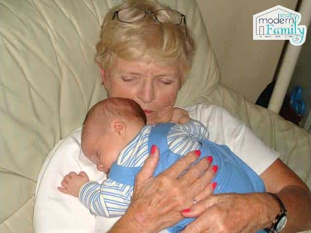 A baby lying on his grandma\'s shoulder.