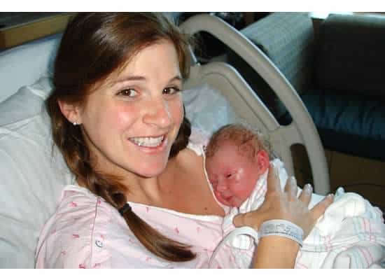 A woman holding a new born baby.