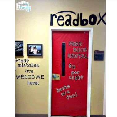 A classroom door decorated with red paper and text on it.