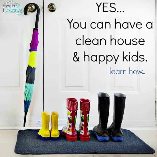 Three pairs of rain boots on a mat with an umbrella resting on a door knob with text above them.