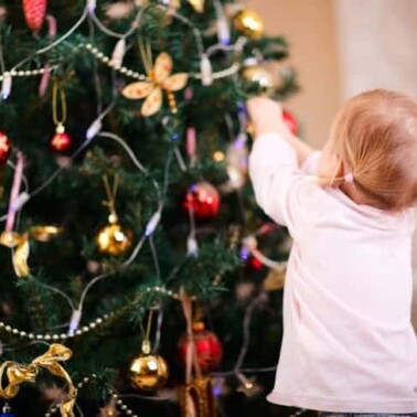A child decorating a Christmas tree.