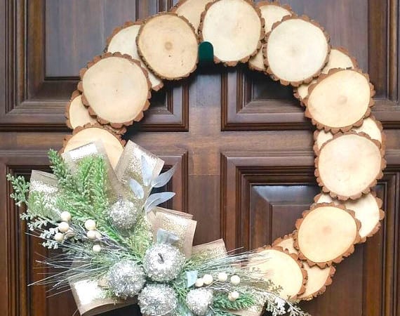 A homemade wooden wreath with a bow hanging on the front door.