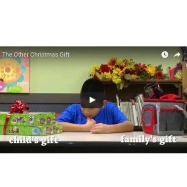 A video of a boy sitting near wrapped presents.