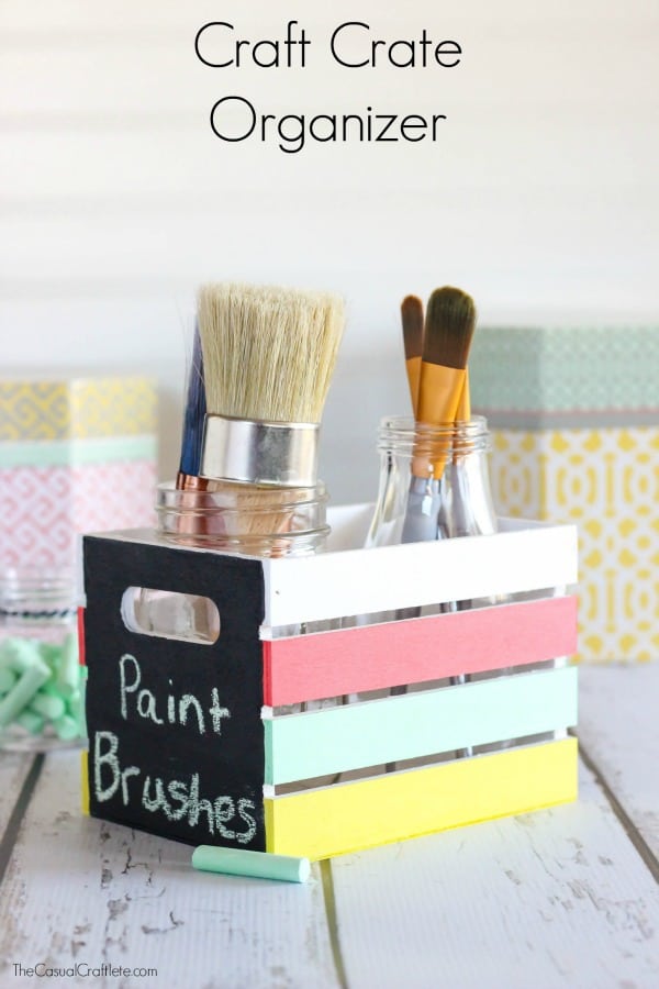 A homemade wooden container with paint brushes in it.