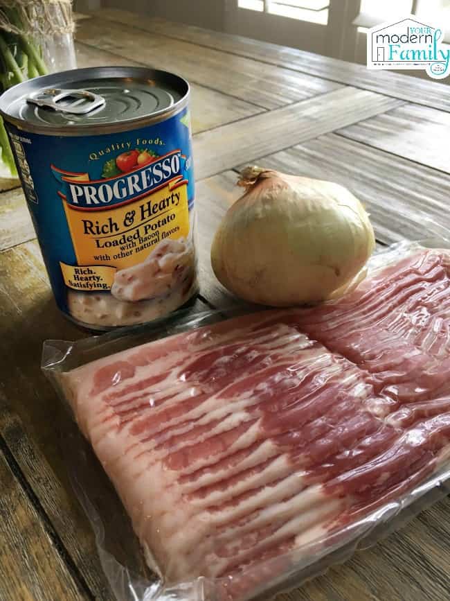 A close up of ingredients including bacon, onion and a can of Progressive Potato Soup.