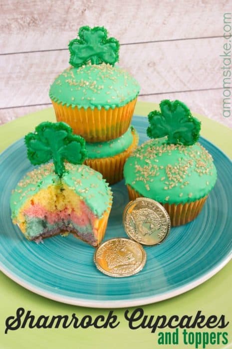 St. Patrick\'s Day cupcakes on a blue plate with two gold coins beside them.