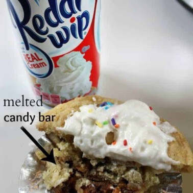 A cookie cake with a can of Reddi Wip behind it.