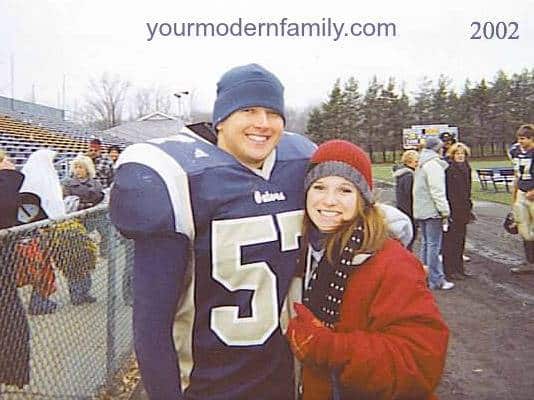 A college football player and his girlfriend posing for a picture after the game.