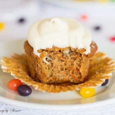 A close up of a Carrot Cupcake with a bite out of it.
