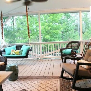 A screened in porch filled with porch furniture.