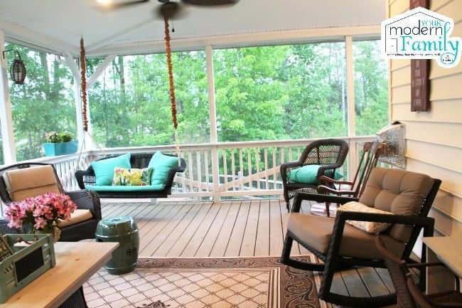 A screened in porch filled with porch furniture.