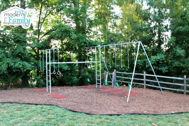 A metal swing set with numerous swings and gymnastic rings.