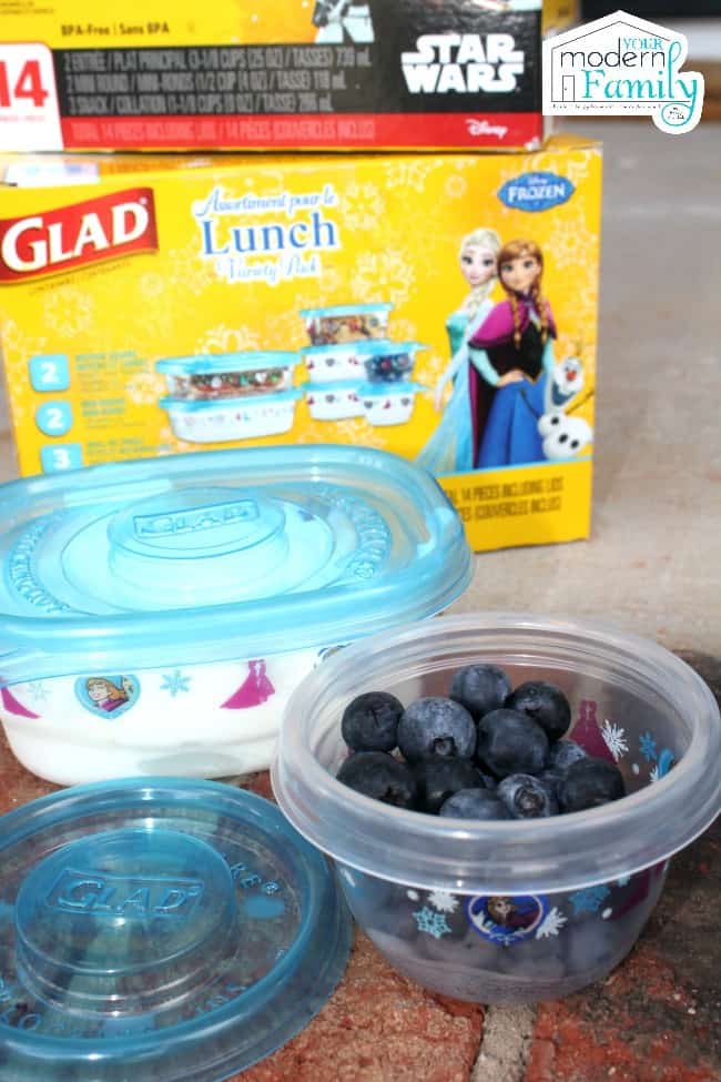 A variety of sizes of plastic containers filled with food with a box of Glad containers behind them.
