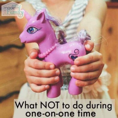 A girl holding a pink My Little Pony.