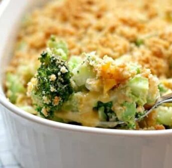 A casserole dish with a spoonful of broccoli and melted cheese.